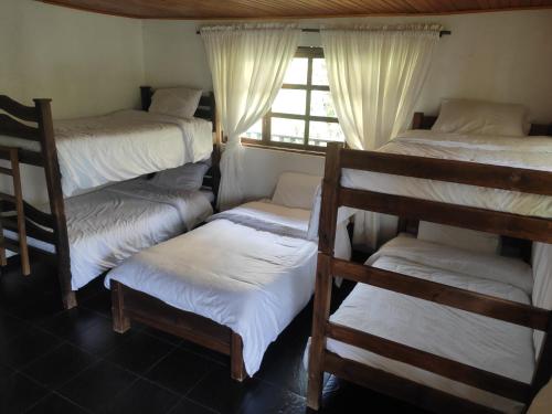 GüicánHotel Brisas del Nevado的客房设有四张双层床和窗户。