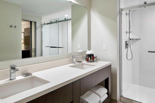 温莎Marriott Hartford/Windsor Airport的一间带两个盥洗盆和大镜子的浴室