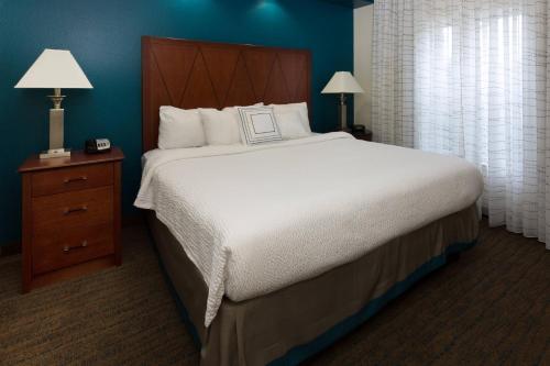 巴吞鲁日Residence Inn by Marriott Baton Rouge near LSU的一间卧室配有一张大床和木制床头板