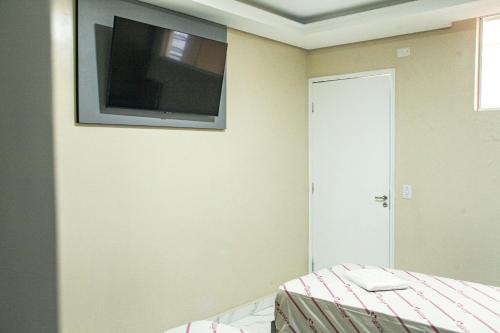 圣保罗Hotel Tenda Obsession的卧室配有壁挂式平面电视。