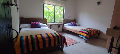 金巴亚Fincas Panaca Herreria 1 - San Judas的客房设有两张床和窗户。