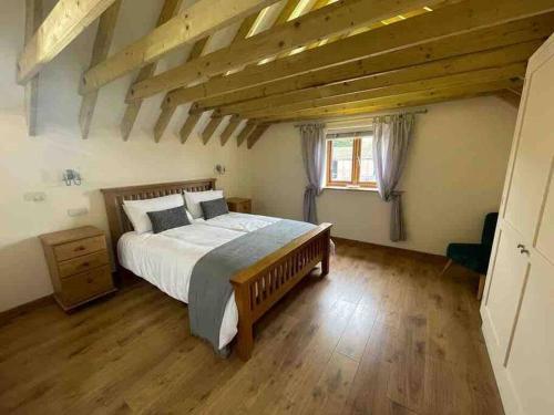 诺里奇Charming Norfolk Barn Conversion in Barnham Broom的一间卧室设有一张大床,铺有木地板