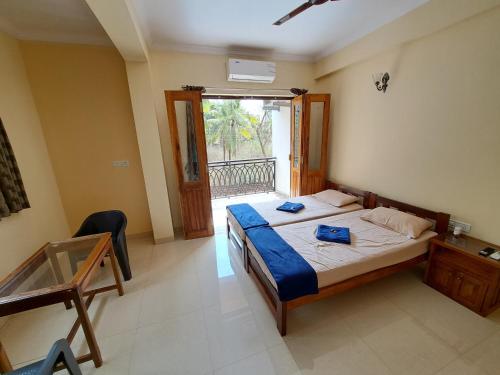 TivimD'souza's Guest House的一间卧室配有一张床和一张玻璃桌