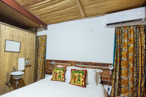 卡萨内Nxabii Cottages的卧室配有一张床,墙上配有电视。