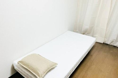 Sanukiマリオン屋島東906号的一张白色的床,上面有枕头