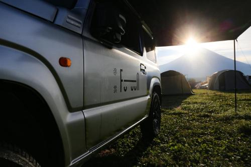 富士宫市FUUUN S Camping Car的一辆停放在田野的白色卡车,有帐篷
