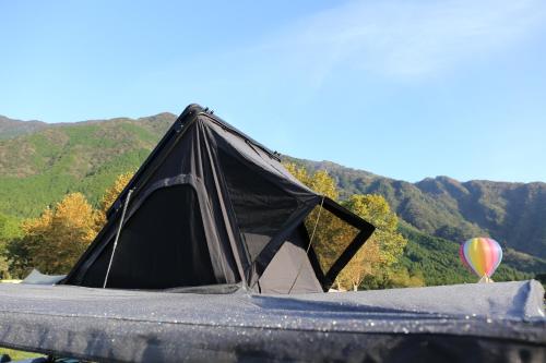 富士宫市FUUUN S Camping Car的黑色帐篷和热气球