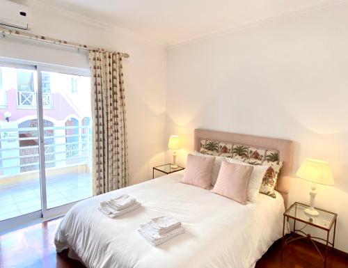 维拉摩拉Vilamoura Central 2 Bedroom Apartment的卧室配有一张大白色床和窗户