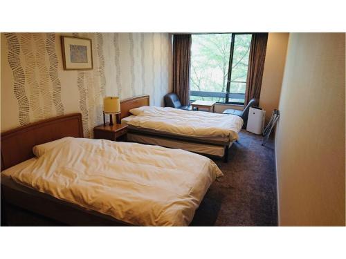 岐阜公园酒店的酒店客房设有两张床和窗户。