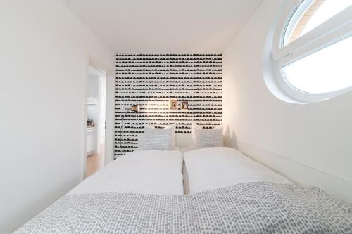 KrumminKomfort-Hausboote am Naturhafen Krummin的白色的卧室设有床和窗户