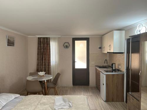姆茨赫塔Oldtown Apartments的酒店客房设有一张床铺、一张桌子和一间厨房。
