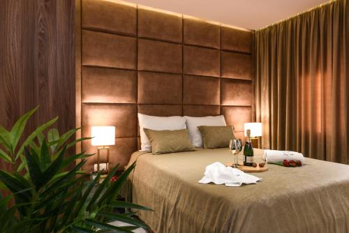 扎达尔Luxury Rooms LaVie - Standard Rooms的一间卧室配有一张带两盏灯和酒杯的床
