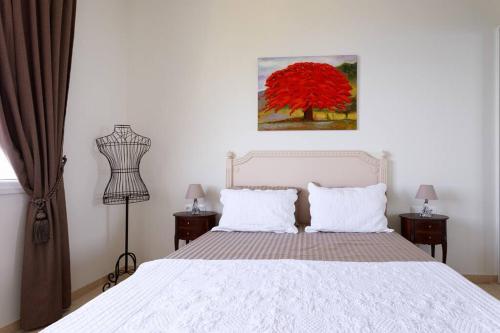 滨海自由城Sea side apartment between Nice and Monaco - 2的卧室配有白色的床和红色的树