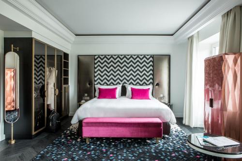 巴黎Fauchon l'Hôtel Paris的卧室配有一张带粉红色枕头的大床