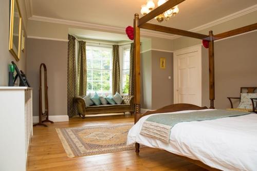 SetcheyThe Grange Manor House, Norfolk的一间卧室配有一张床,窗户配有一张沙发