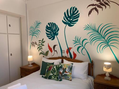 雅典雅典娜公寓的一间卧室配有一张带植物壁画的床