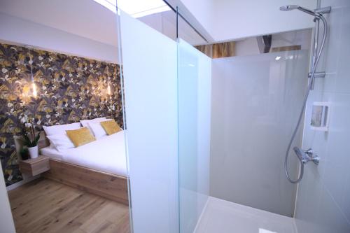 那慕尔Chambres4you的一间卧室设有一张床和一个玻璃淋浴间