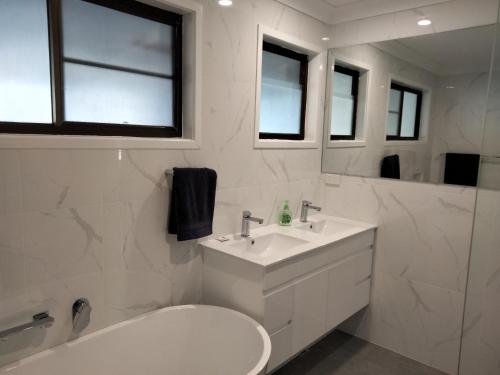 安娜湾Birubi Beach House的一间带水槽、卫生间和镜子的浴室