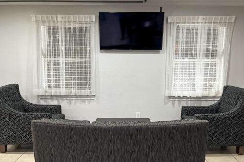 哥伦布Quality Inn & Suites的客厅配有2把椅子和平面电视