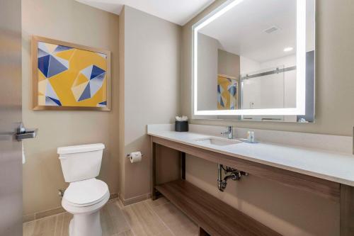 奥兰多Pestana Orlando Suites - Lake Buena Vista的浴室设有卫生间和带镜子的盥洗盆
