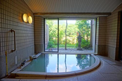 箱根乐之花酒店的一个带窗户和喷泉的房间的游泳池