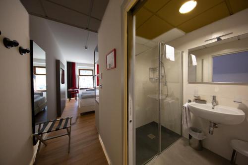 加尔达湖滨中央酒店的带淋浴、盥洗盆和镜子的浴室