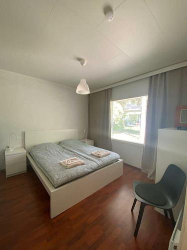 纳坦利Cozy 73m2 terraced house with sauna的卧室配有床、椅子和窗户。