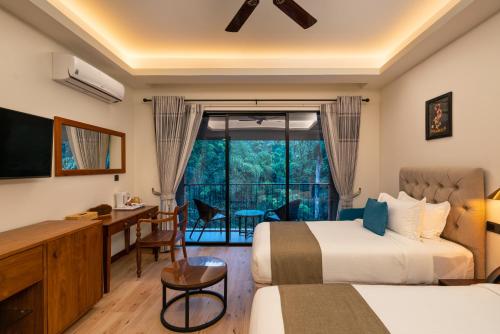 基图尔格勒Moksha at Kitulgala - Rainforest Boutique Hotel的酒店客房设有两张床、一张书桌和一个窗户。