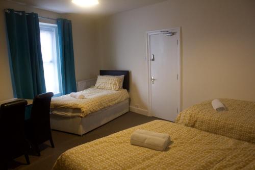 滨海韦斯顿Elm Tree Guest House的一间卧室设有两张床和窗户。