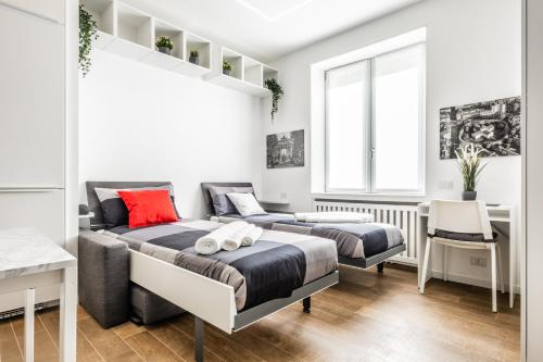 米兰City Life House-RED Free Parking San Siro & Duomo的一间卧室设有两张床、一张桌子和一个窗口。