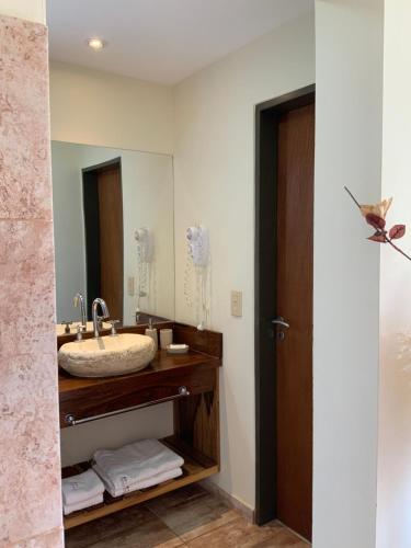 诺诺LA TOSCANA casas y suites的一间带水槽和镜子的浴室