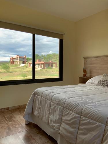 诺诺LA TOSCANA casas y suites的一间卧室设有一张床和一个大窗户