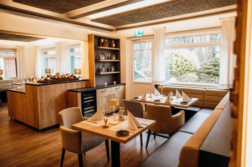 诺尔德霍尔茨Landgasthof "Zum grünen Walde"的一间带桌椅和柜台的餐厅