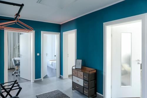 因戈尔施塔特Lumen Homes - Design-Apt. nahe Audi und Altstadt, 3 Zimmer, NETFLIX的一间拥有蓝色墙壁的房间和一间带梳妆台的房间