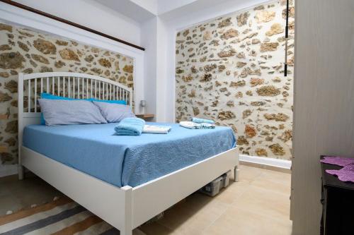KroústasKonstantis的石墙客房的卧室配有一张床