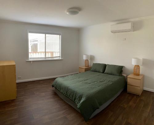 Country retreat的一间卧室设有一张绿色的床和一个窗户。
