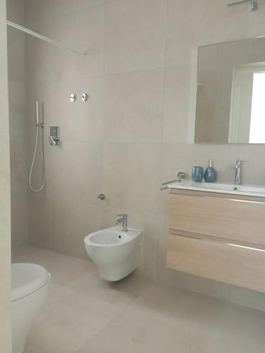 阿兰奇湾城Sea & Country Rooms的白色的浴室设有水槽和卫生间。