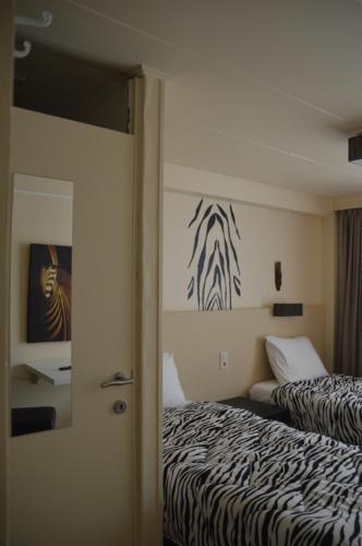 佐内贝克B&B The Protea的卧室配有两张床,墙上挂有斑马画