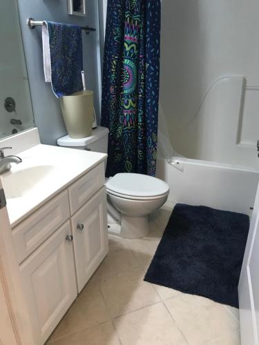 大洋城Beautiful Condo的浴室设有卫生间水槽和淋浴帘