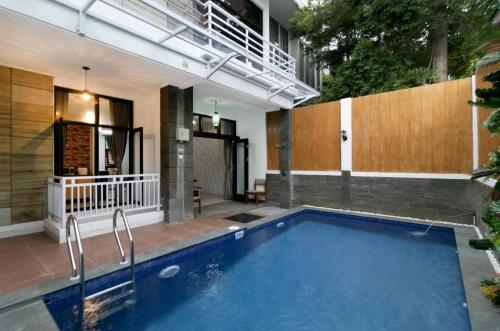 万隆Vila Keluarga Syariah Mawar 82, Dago Resort 4BR dengan Privat Pool BBQ dan Rooftop的大楼前的游泳池