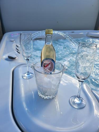伯伊莱海尔库拉内Thermae D'Olimpia & SPA - Adults Only 14 Plus的浴缸内的一瓶葡萄酒和两杯酒