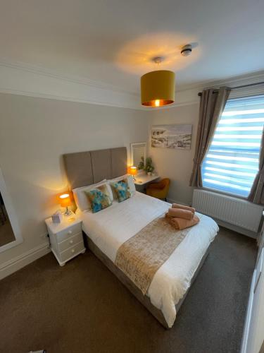 斯沃尼奇Rivendell Guest House的一间卧室设有一张大床和一个窗户。