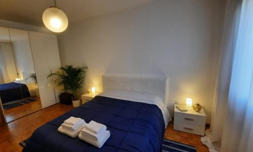 特伦托Verdisuite - Trento centro - Parcheggio privato gratuito的一间卧室配有蓝色的床和毛巾