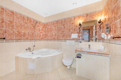 比尔森Hotel Palace的带浴缸、卫生间和盥洗盆的浴室