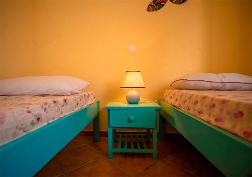 马约城Villa Atum. Stella Maris Exclusive的一间卧室配有两张床和一张带台灯的桌子