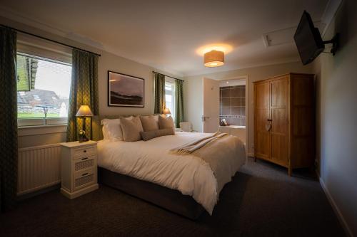 德拉姆纳德罗希特Balmridge House, Loch Ness, Bed & Breakfast的一间卧室设有一张大床和一个窗户。