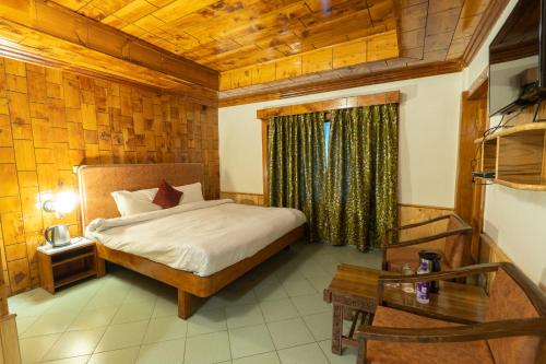 马拉里Vivaan Stays -Holiday Home International的一间卧室设有一张床和木制天花板