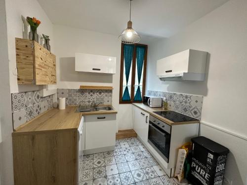 巴涅尔德比戈尔Appartement spacieux - proche centre et therme的小厨房配有白色橱柜和炉灶。