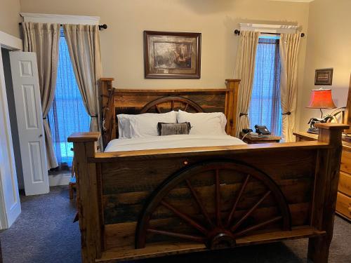 布兰森Historic Branson Hotel - Horseshoe Room with King Bed - Downtown - FREE TICKETS INCLUDED的一间卧室配有一张木床,铺有木 ⁇ 板