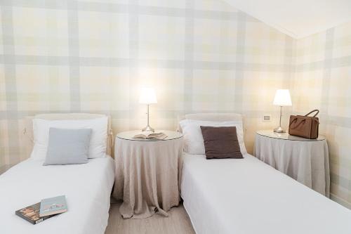 西斯蒂亚纳伊登酒店的一间设有两张床和两张台灯的桌子的房间